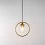 A gold ring pendant light with a clear globe shade illuminated with the light on highlighting the modern circular frame and suspended minimalist design.