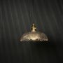 Crystal glass pendant light glowing against dark background highlighting detailed glass texture.