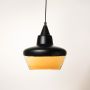 Black and amber glass pendant light shown off on white background modern ceiling lamp design for kitchen and dining decor.