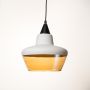 Pendant light with white and amber glass shade displayed off on white background contemporary ceiling lamp for homes.
