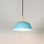 Blue pendant light on white background with wooden accent holder is a minimalist Scandinavian design ceiling lamp.