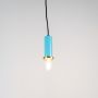 Blue pendant light turned on with glowing bulb and brass accent displayed on clean white background.