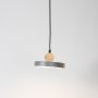 Wood and metal pendant light glowing on white background with circular modern design for stylish home interiors.