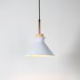 White conical pendant ceiling light with wood top illuminated on white background for stylish dining and modern kitchen lighting.