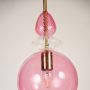 Detailed view of the pink glass pendant shade clear crystal accent and brass rod high quality material.