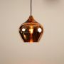 Gold reflective pendant light glowing warmly on white background showing bright illumination and sleek modern metallic design.