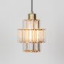 A tiered glass pendant light with the bulb turned on showcasing its warm glow and clear layered glass design against a clean white background.