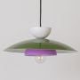 Closeup of multicolor metal pendant light showing green dome purple inner ring and white top for modern interior decor.