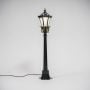 Solar lamp post glowing warmly with black frame and golden detailing ideal for illuminating modern outdoor spaces.