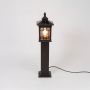 Outdoor solar pole light in black metal with glass lantern displayed on white background for garden pathway lighting use.