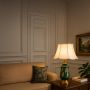 Ceramic green and gold base lamp with a white fabric shade creating a perfect balance of artistry and elegance for sophisticated decor.