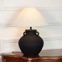Minimal black ceramic table lamp with sculpted ear handles matte finish base and fabric shade on clean white background.