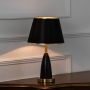 Black and gold table lamp with fabric shade turned on against white background stylish modern decor table lamp.