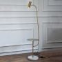 Gold floor lamp with side table and marble base photographed on white background with light turned on for product display.