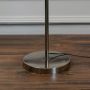 Closeup of chrome floor lamp base and stand – sleek contemporary lighting design for home decor.