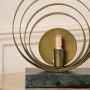 Closeup of circular brass ring table lamp showcasing fine metal texture and sleek marble base designed for high-end interior styling.