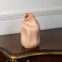 Beige ceramic vase with artistic organic form and smooth matte finish displayed on white background for decor styling.