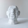 Single white geometric face sculpture with faceted design ideal for contemporary home or office tabletop decoration.