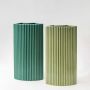 Set of modern teal ceramic vases featuring vertical ribbed patterns styled  for a sophisticated home decor display.