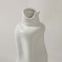 Closeup view of a white ceramic sculptural vase highlighting its smooth artistic curves and modern handcrafted design.
