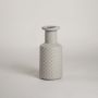Light grey ceramic vase with geometric textured pattern placed on a bright white background ideal for minimal refined decor styling.