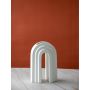 Contemporary white arch decor piece displayed on a plain white surface highlighting its sculptural form with soft curves and a modern minimalist appeal.