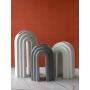 Grey arch shaped decor piece shown in a styled grouping setting highlighting its modern sculptural curves and clean aesthetic for contemporary interiors.