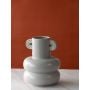 Modern grey vase with rounded form and decorative handles shown against a simple white-style backdrop.