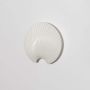 A modern white shell shaped decorative wall plate displayed on a clean white background showing its smooth ridged texture for a minimal elegant home decor look.