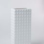 Closeup of the white textured ceramic vase showing its raised geometric pattern and smooth finish for modern minimal home styling.