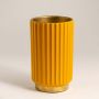 Closeup of ribbed ceramic vase in mustard yellow finish highlighting vertical texture smooth glaze and modern tabletop decor styling.