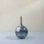 Glossy grey glass jar with round shape and tall lid displayed on white background for modern decorative interior use.
