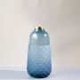 Tall blue glass vase with embossed scallop detailing and metallic rim displayed on clean white background decorative glass vase.