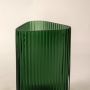Closeup of green ribbed glass vase highlighting its vertical pattern sleek finish and sophisticated geometric shape.