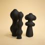 Collection of uniquely shaped black ceramic vases with textured surface creating a striking modern centerpiece for contemporary home decor.