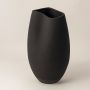 Side view of black ceramic vase with smooth matte finish showing organic curved form and handcrafted minimalist style.
