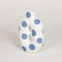 White ceramic decorative vase with blue polka dot pattern ideal for dried flower arrangement and contemporary home decor styling.