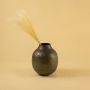 Brown hammered metal vase decor styled in a cozy warm interior adding natural rustic charm to living room consoles.