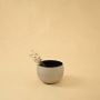 Cream round pot with matte finish and black interior styled in a cozy modern space adding natural minimal decor charm.