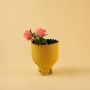 Yellow metal scalloped planter decor styled in a warm modern room adding a bright elegant accent to living room tables and corners.
