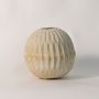 Round textured vase on white background showing hand-sculpted ribbed ceramic design and organic natural tone.