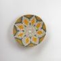 Single handcrafted woven wall plate with green mustard and cream tones shown on a clean white background highlighting its circular design and textured craftsmanship.