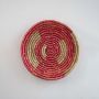 Handcrafted pink wall plate on white background showing detailed woven craftsmanship.
