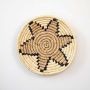 Round handwoven jute basket wall decor in beige with black star pattern rustic boho wall art accent piece for interiors.