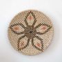 Handmade wicker wall plate decor in natural beige with black and orange detailing for boho wall decoration.