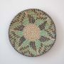 Round wicker wall plate decor handmade with beige green and navy woven pattern ideal for boho wall decoration.