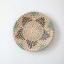 Handwoven wall basket in natural beige with blue and black woven design shown on white background.
