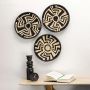 A grouped display of three black and natural rattan wall basket decor plates arranged on a white wall creating a bold artistic statement for modern handcrafted home styling.