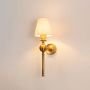 Illuminated antique brass wall lamp with glowing white shade showing warm ambient light on clean white background display.