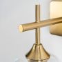 Closeup view of clear glass wall sconce featuring a gold metal mount and exposed filament bulb highlighting its modern craftsmanship and elegant detailing.
